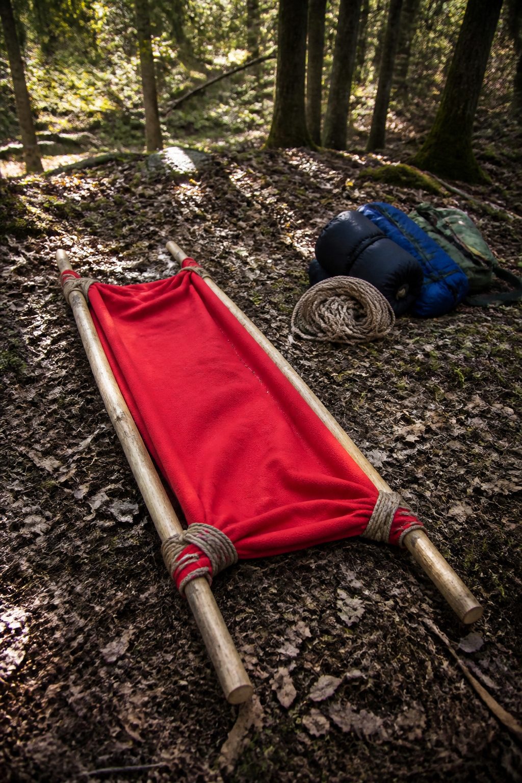 Emergency Preparedness Merit Badge 6 A makeshift stretcher made from poles and a blanket.