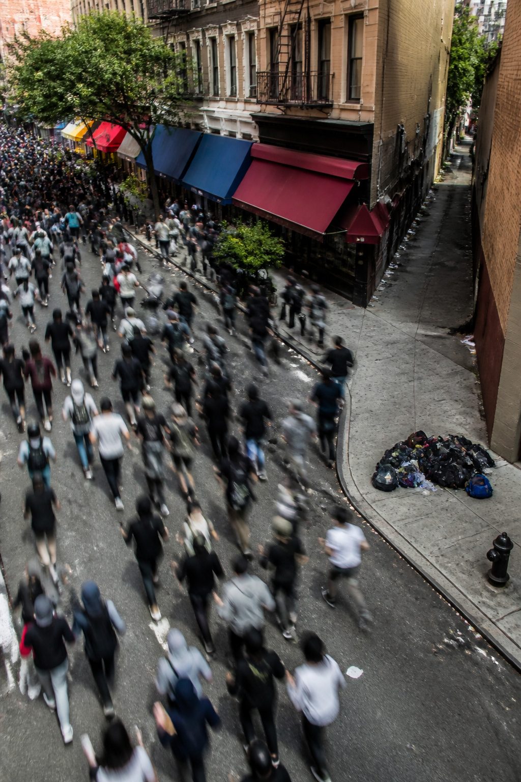 How to Escape a Riot: 9 Steps to Get Out Safely (2026) 4 A crowd of people moving together along a street.