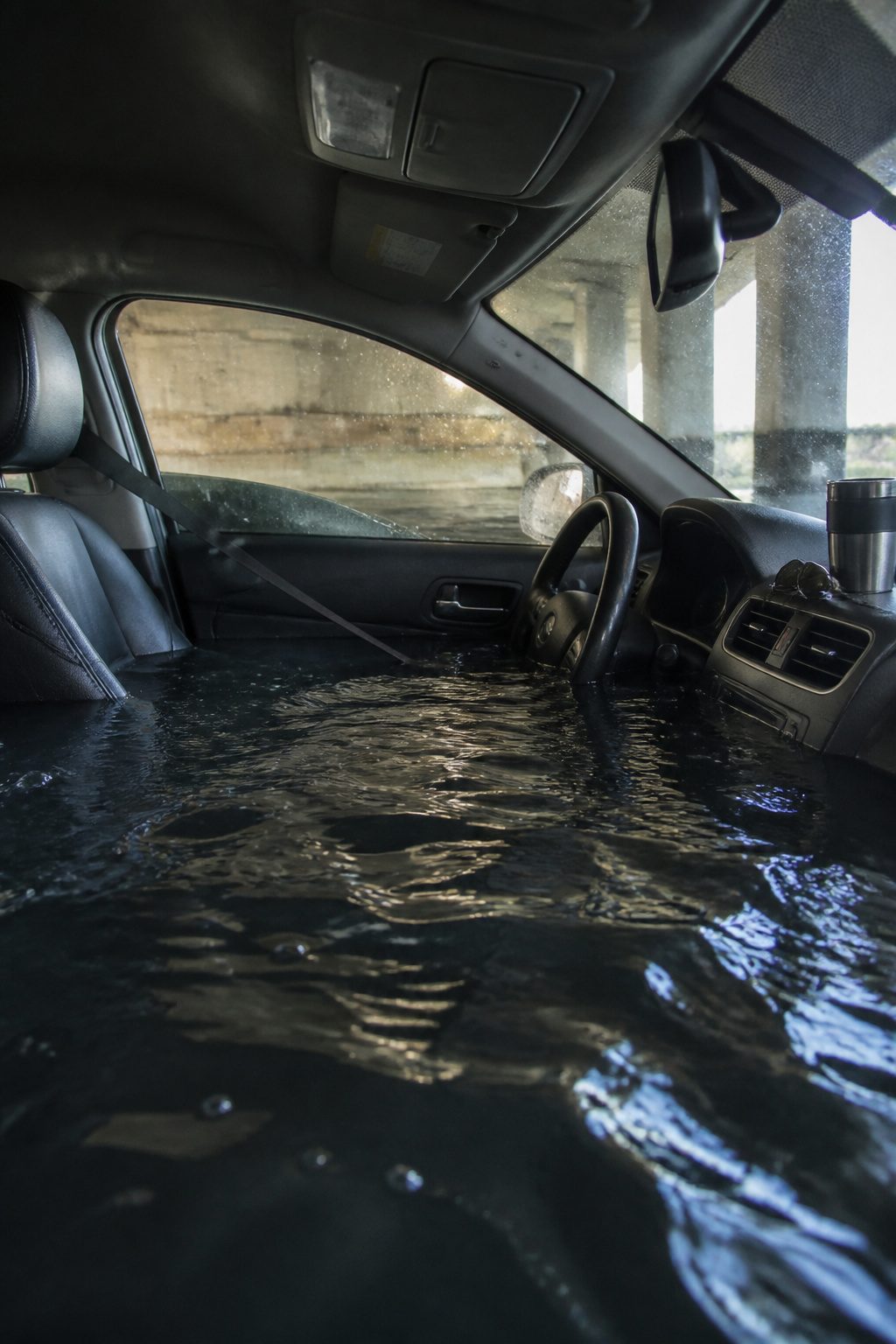 How to Escape a Sinking Car: 5 Steps That Save Lives in 2026 1 A driver sitting in a car with water filling the lower half.