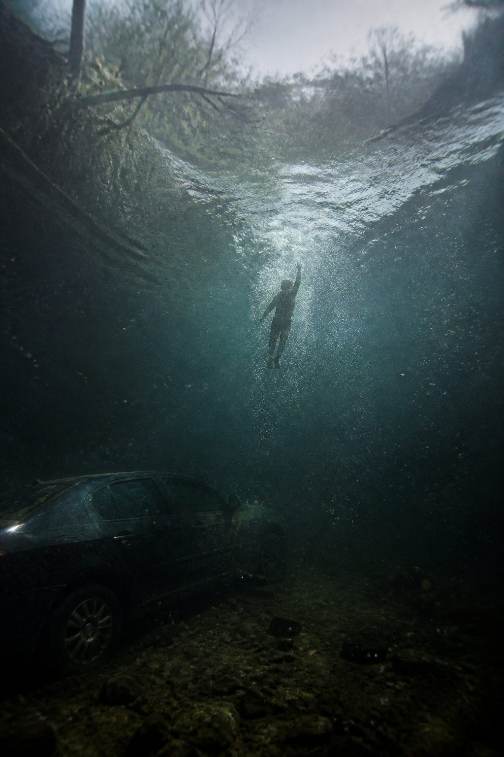 How to Escape a Sinking Car: 5 Steps That Save Lives in 2026 5 Bubbles in water show the way up from a submerged vehicle.