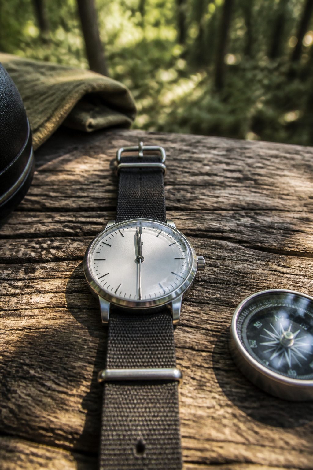 A close-up shot of a flat analog wristwatch on a wooden surface.