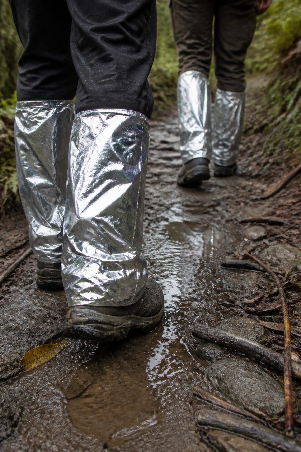 Mylar Blanket Uses: 38 Practical Ideas for Emergencies & Daily Life (2026) 25 Two pairs of mylar gaiters positioned along a muddy hiking path.