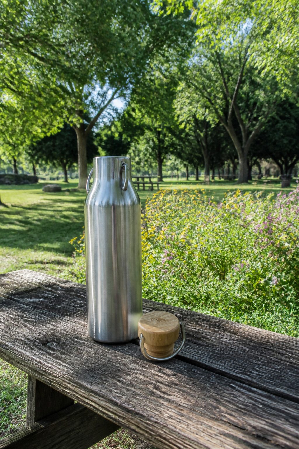 A Klean Kanteen water bottle on a wooden bench.